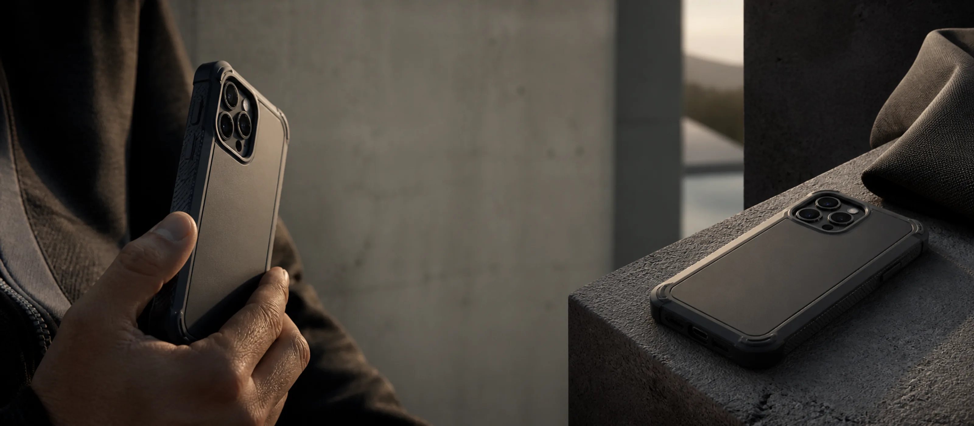 Graphite protective phone case with reinforced corners on a concrete surface
